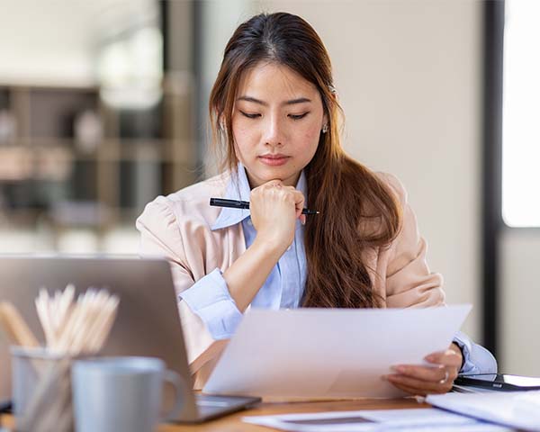 Person reviewing notes while working on instructional design at a laptop